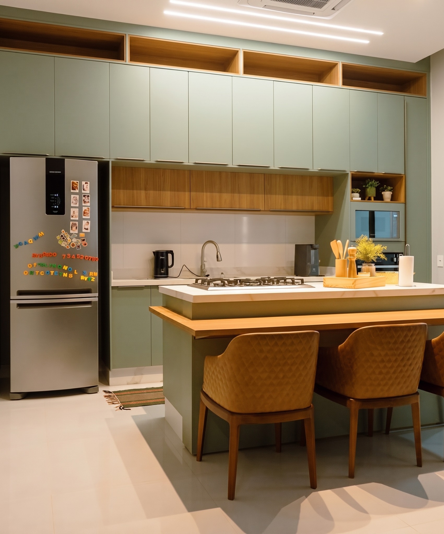 Cozinha planejada em verde suave com bancada e nichos de madeira