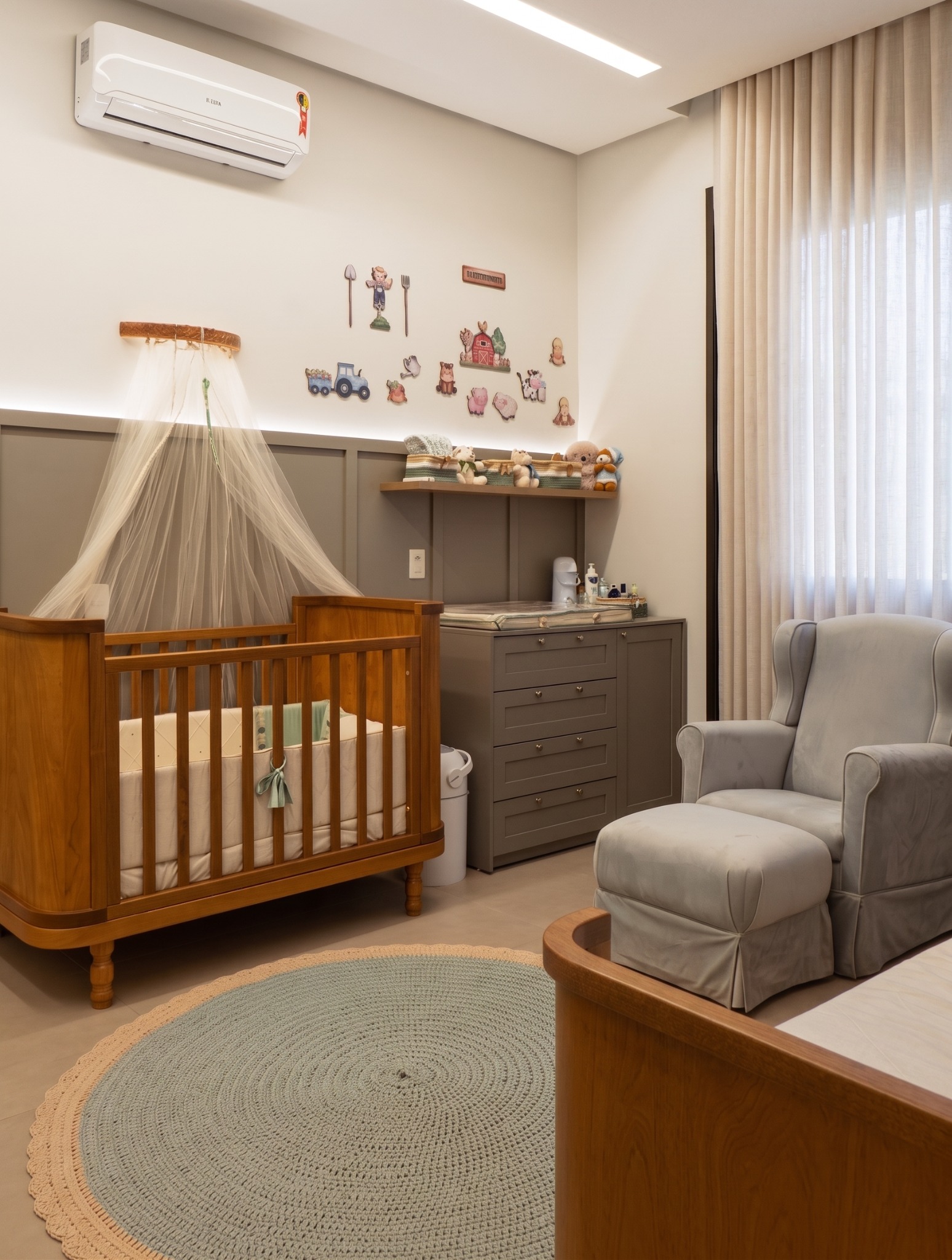 Quarto infantil com berço, poltrona e marcenaria em madeira